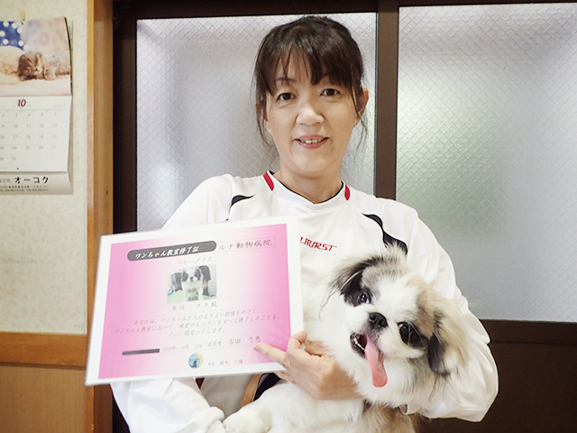 卒業証書を手に持つ飼い主と犬